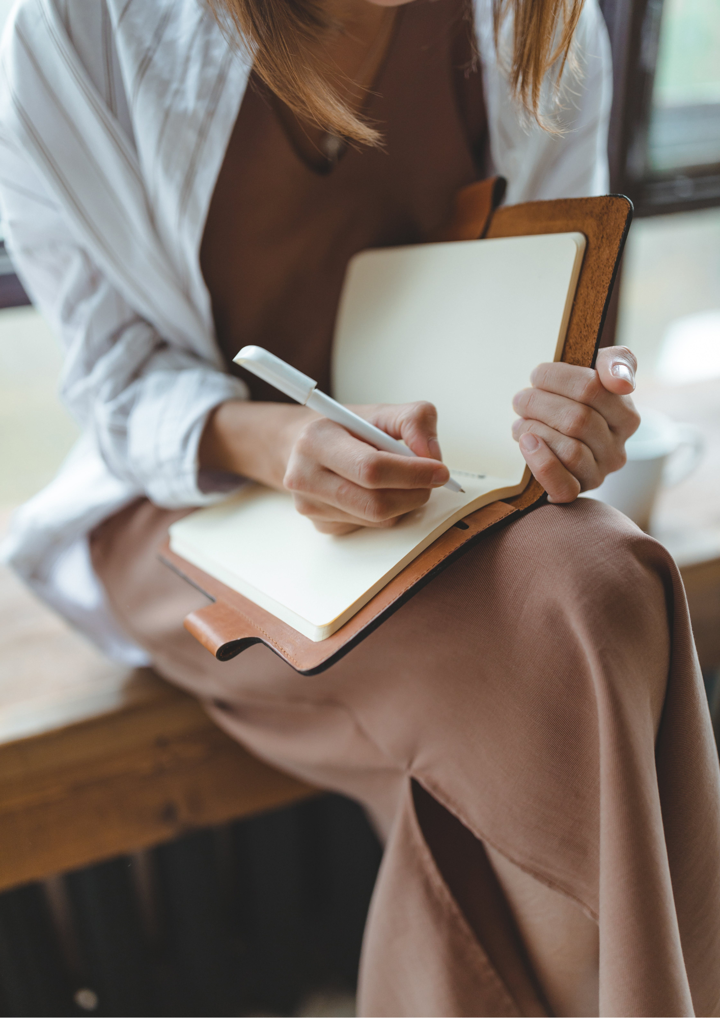 Woman sits journalling as self reflection following a coaching session